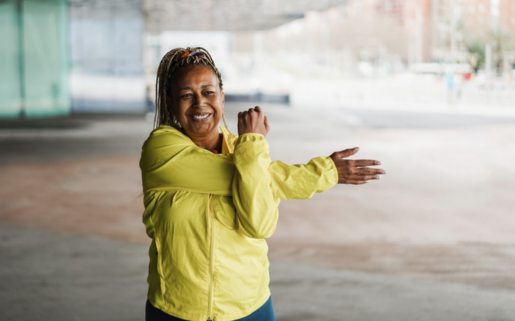 Black woman smiles and stretches before exercising