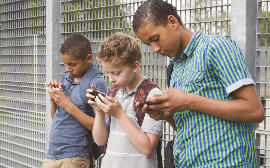 Teenage boys looking at their phones.