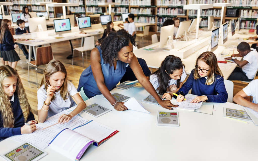 Teacher works with students in school library