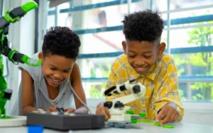 Two boys smile and enjoy working together on science based school project.